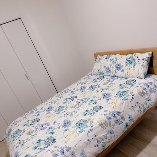 大阪Free Parking Namba south Villa 4 rooms 120m2的一间卧室,床上摆放着蓝色鲜花