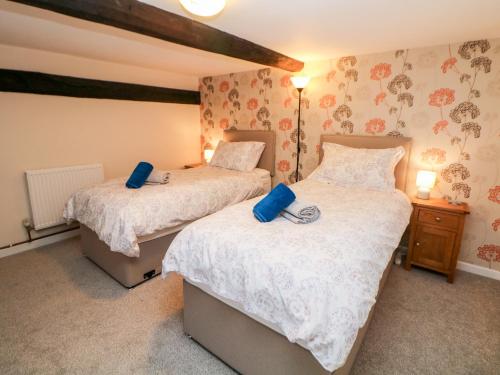 卡斯尔顿Wilson Eyre Cottage的一间卧室配有两张带蓝色枕头的床。