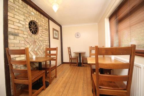 彼得伯勒Highfields Holidays bed & breakfast的用餐室配有木桌和椅子