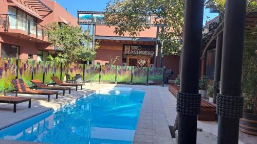 查克拉斯德科里亚天堂广场佩蒂酒店的一座带躺椅的游泳池位于大楼旁