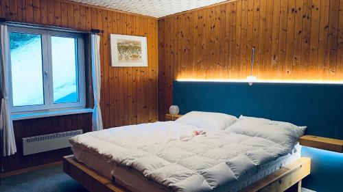 芙露姆赛山Chalet Schwendihus - CharmingStay的窗户客房内的一张大床