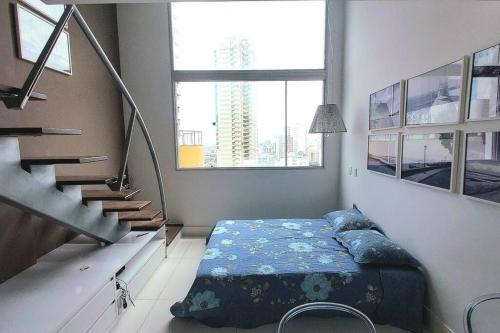 萨尔瓦多Lindo Loft Beira-Mar na Vitória的一间卧室配有带枕头的床和楼梯。