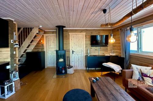 兰帕兰德Cozy cabin with incredible views and sauna的客厅设有壁炉和木制天花板。