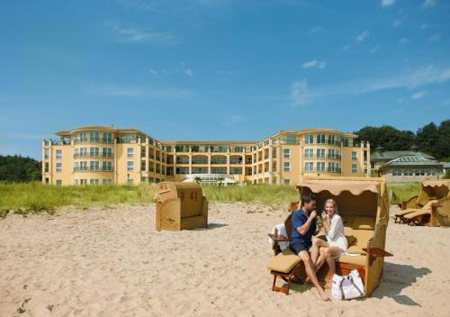 沙博伊茨Hotel Gran BelVeder & Ostsee Therme Resort & Spa的两人坐在沙滩上的椅子上