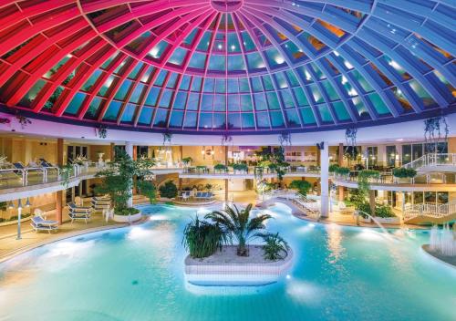 沙博伊茨Hotel Gran BelVeder & Ostsee Therme Resort & Spa的一座大型室内游泳池,位于一座拥有圆顶天花板的建筑中