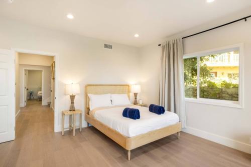 洛杉矶Sycamore Villa II的一间卧室配有一张带两个蓝色枕头的床