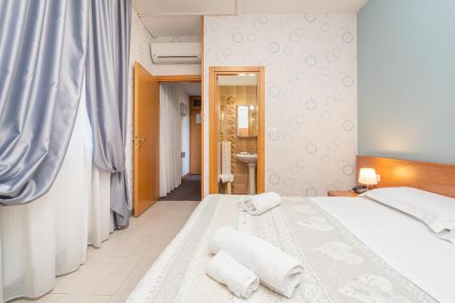 博洛尼亚多纳泰罗酒店的一间卧室配有一张床,上面有两条毛巾