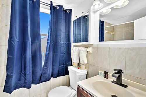 好莱坞Coastal Sunset的浴室设有卫生间和蓝色的浴帘。
