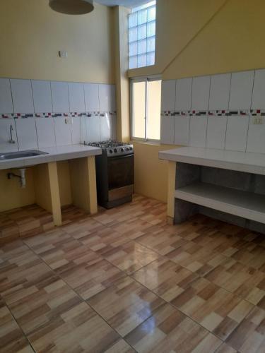 Caleta CruzDepartamento de Pablito Junto al Mar的一间大厨房,配有白色的橱柜和炉灶