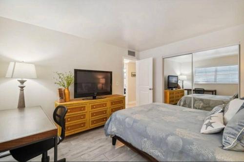 那不勒斯Vanderbilt Mercado Villa Oasis.的一间卧室配有一张床和一台平面电视