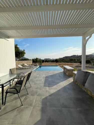 卡尔帕索斯Eleon Luxury Villa的一个带桌椅的庭院和一个游泳池