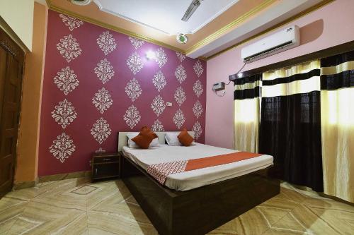 BihtaOYO Flagship Ashoka Guest House的一间卧室配有一张床和紫色的墙壁