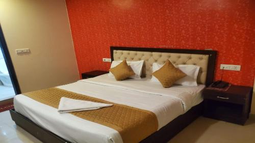 新德里Airport T Palace的一间卧室设有一张红色墙壁的大床