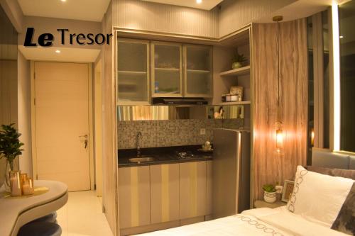 泗水Le Tresor Benson Apartment at Supermal Pakuwon的一间带水槽和冰箱的小厨房