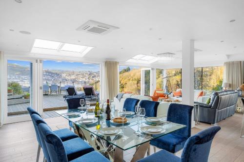 金斯韦尔Homefield - Chic charm with unrivalled river views的一间带桌子和蓝色椅子的用餐室