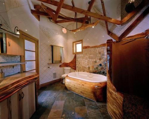 瓦尔达维德Le Sculptural Exitchalets Laurentides Spa的大型浴室设有大型木制浴缸。