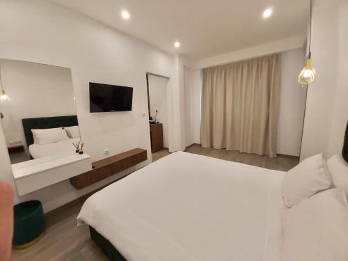 雅典Real City Suites Syntagma的酒店客房设有白色的床和电视。
