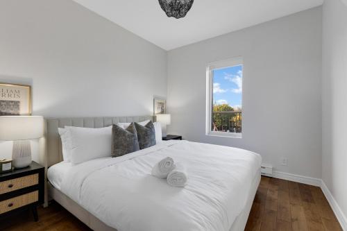 蒙特利尔Lofts de la petite Italie的卧室配有一张大白色床和窗户