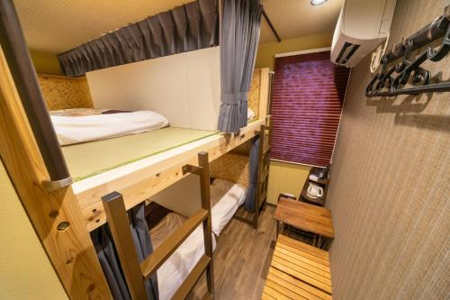 东京IKIDANE Cozy Hotel Haneda Airport - Vacation STAY 25827v的客房设有两张双层床和一扇窗户。