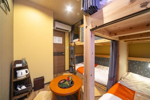 东京IKIDANE Cozy Hotel Haneda Airport - Vacation STAY 25843v的客房设有两张双层床和一张桌子。