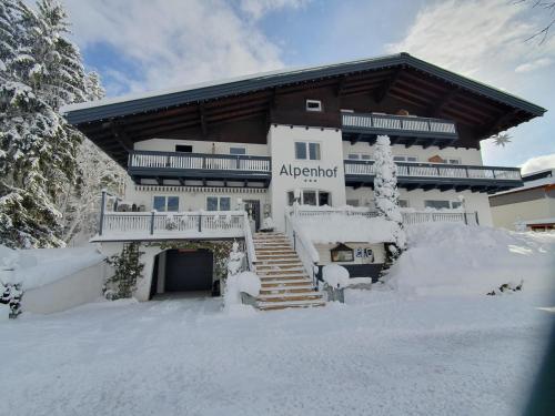 滕嫩山麓圣马丁Boutique Hotel Alpenhof的前面有雪的大建筑