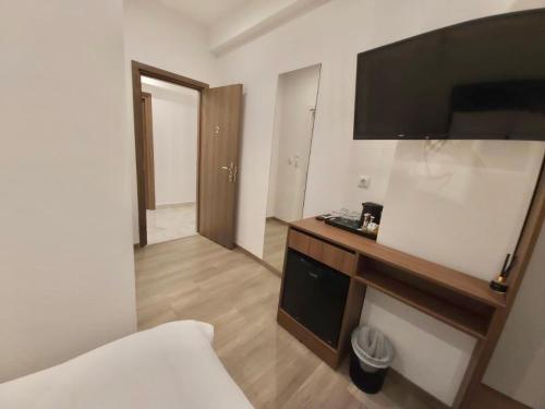 雅典Real City Suites Syntagma的酒店客房设有一张床和墙上的电视