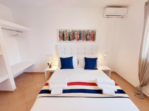 圣玛丽亚Branco Sea Holiday Apartments的卧室配有带蓝色枕头的大型白色床