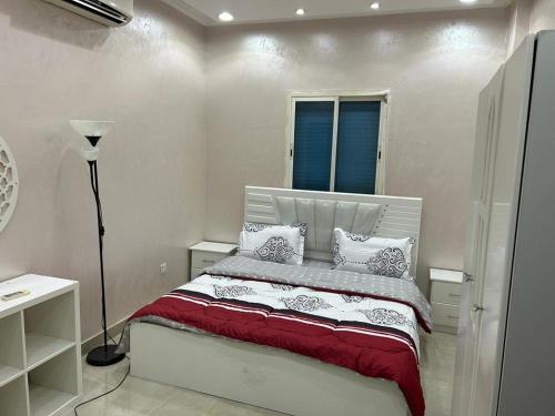 欧普尔شالية 3 غرف على شرم ابحر - جدة - السعودية的一间卧室配有红色和白色枕头的床