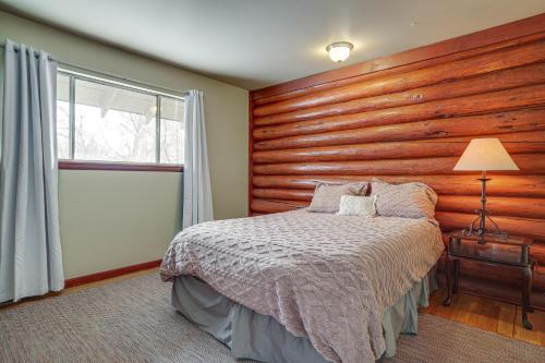 兰德Quiet Lander Cabin Rental on Quarter-Acre Land的一间卧室设有木墙、一张床和一个窗户