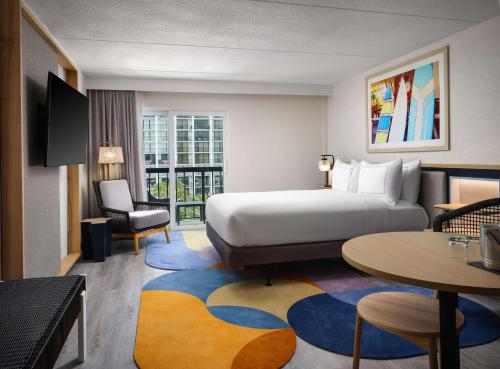 可可比奇Hilton Garden Inn Cocoa Beach-Oceanfront, FL的酒店客房配有一张床铺和一张桌子。