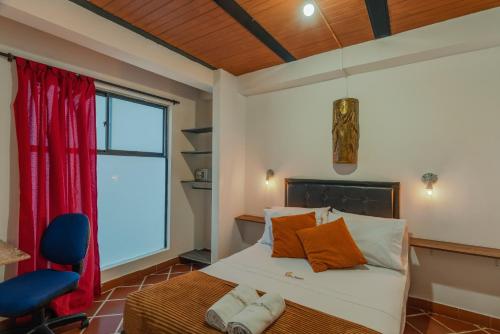 麦德林Casa Los Naranjos Hostal的一间卧室配有带橙色枕头的床和窗户。