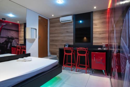 贝洛奥里藏特Motel Fantasy 1的一间卧室配有一张床和两个红色吧台凳