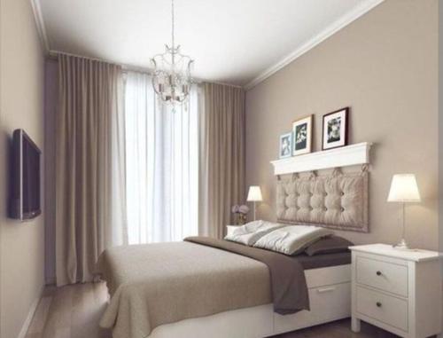 科连特斯SUITES CORRIENTES的一间卧室配有一张大床和一个吊灯。