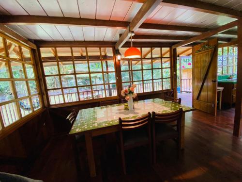 明多Wooden House Mindo - Casa de Las Nevadas的一间带桌椅和窗户的用餐室