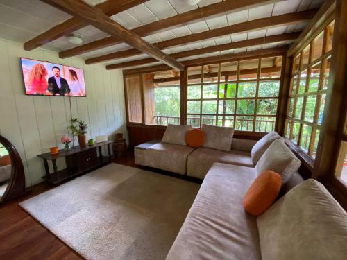 明多Wooden House Mindo - Casa de Las Nevadas的带沙发和电视的客厅
