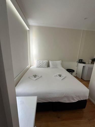 卡西诺Tattersalls Hotel Casino的卧室配有白色的床和2盘盘