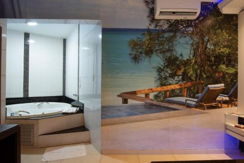 孔塔任莫泰幻想2公寓式酒店（仅限成人）的带浴缸的浴室,享有海景。