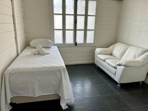 瓜鲁柳斯Pousada Casa da Noiva的客房设有床、沙发和窗户。