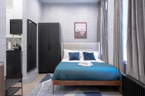 纽约Apartment 256: Upper West Side的一间卧室配有一张带蓝色床单的床和一扇窗户。
