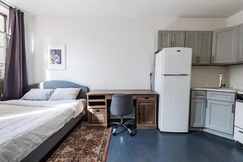 纽约Apartment 1407: East Village的一间卧室配有一张床、一张书桌和一台冰箱
