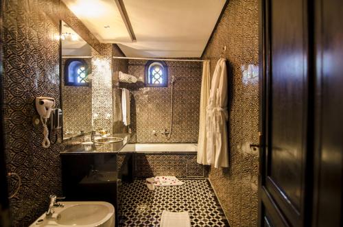 非斯奥梅亚宫套房Spa酒店的一间带水槽、卫生间和镜子的浴室