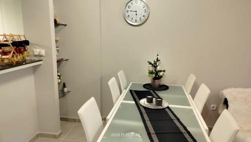格兰阿利坎特Nova Beach Apartment 41的餐桌、椅子和墙上的时钟