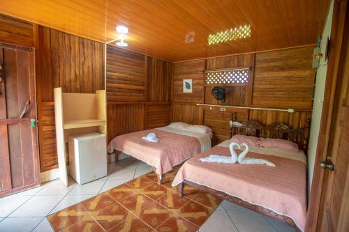 福尔图纳提奥菲利克斯经济山林小屋的木墙客房的两张床