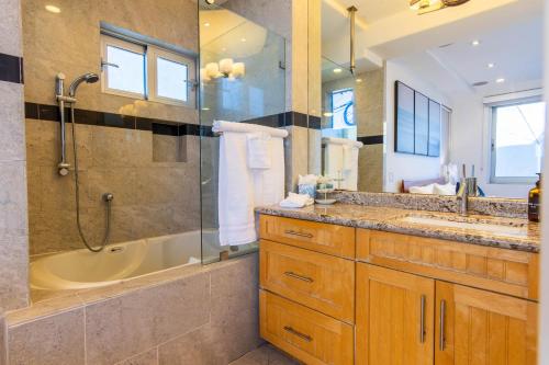 圣地亚哥Ocean view, two-level condo with stunning view, decks, fast WiFi & fireplace的带浴缸、水槽和淋浴的浴室