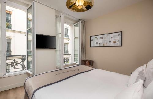 巴黎Hôtel Littéraire Arthur Rimbaud, BW Signature Collection的卧室配有白色的床和2扇窗户。