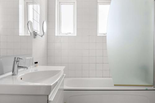 锡姆里斯港Hotel Svea - Sure Hotel Collection by Best Western的白色的浴室设有水槽和浴缸。