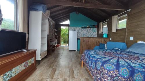 因比图巴Koa Cabana praia do luz的一间卧室配有一张床和一台平面电视