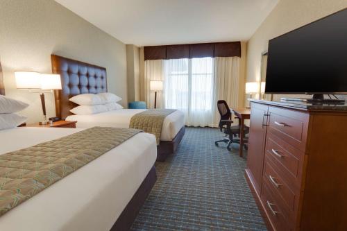 圣查尔斯Drury Plaza Hotel St. Louis St. Charles的酒店客房设有两张床和一台平面电视。