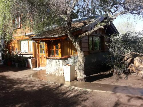 吉亚迪诺镇Cabaña villa giardino C.R的小木屋前面有棵树
