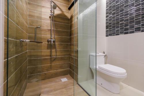 古晋56酒店的一间带卫生间和玻璃淋浴间的浴室